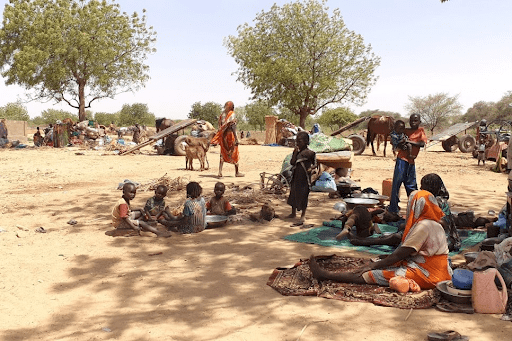 Refugees fleeing recent violence in Sudan’s Darfur region sit in shade near the town of Adre, Chad. © UNHCR